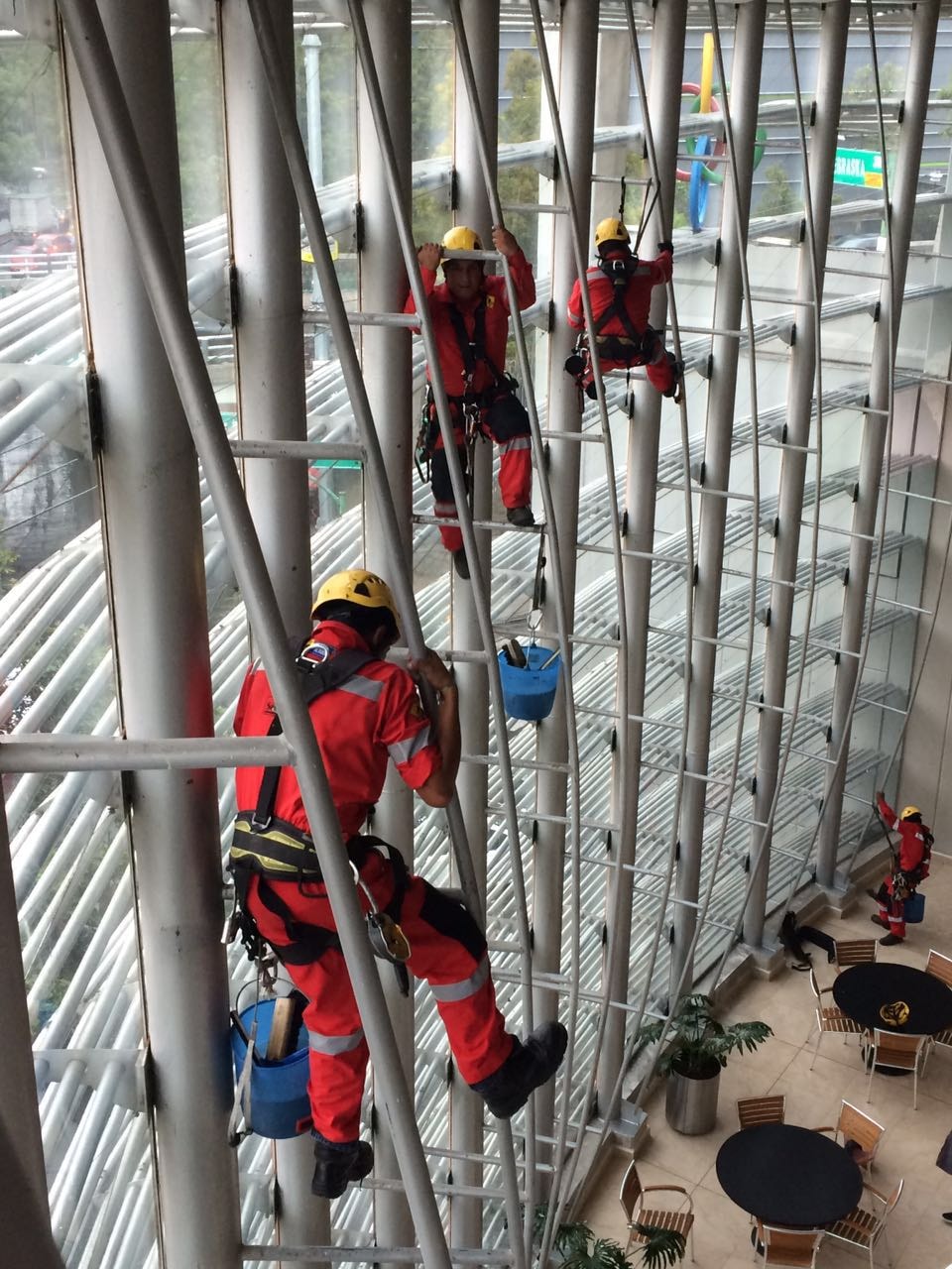 Técnicos BRAGO en rappel limpiando cristales de edificio de vidrio